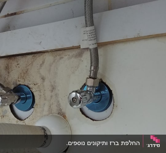 צינורות מים מחוברים לברזים מתכתיים בקיר